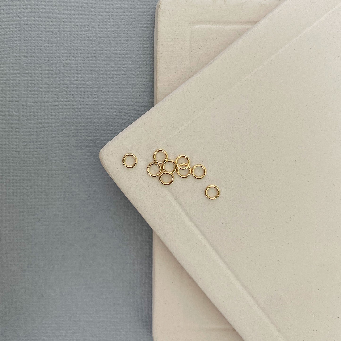 A 10K gold jump ring resting on a neutral background, highlighting its circular shape and rich yellow gold color.