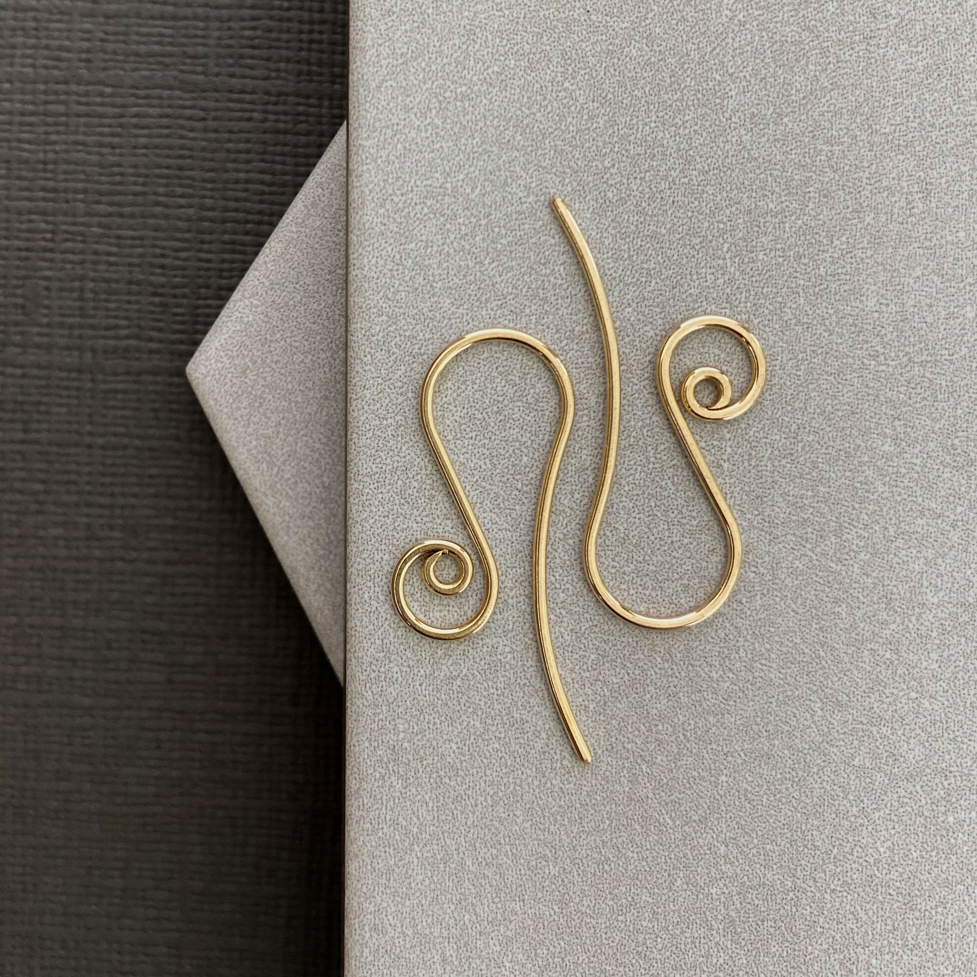 Close-up of 10K solid gold spiral earring hooks, showcasing their smooth, polished finish.
