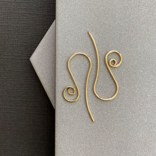 Close-up of 10K solid gold spiral earring hooks, showcasing their smooth, polished finish.