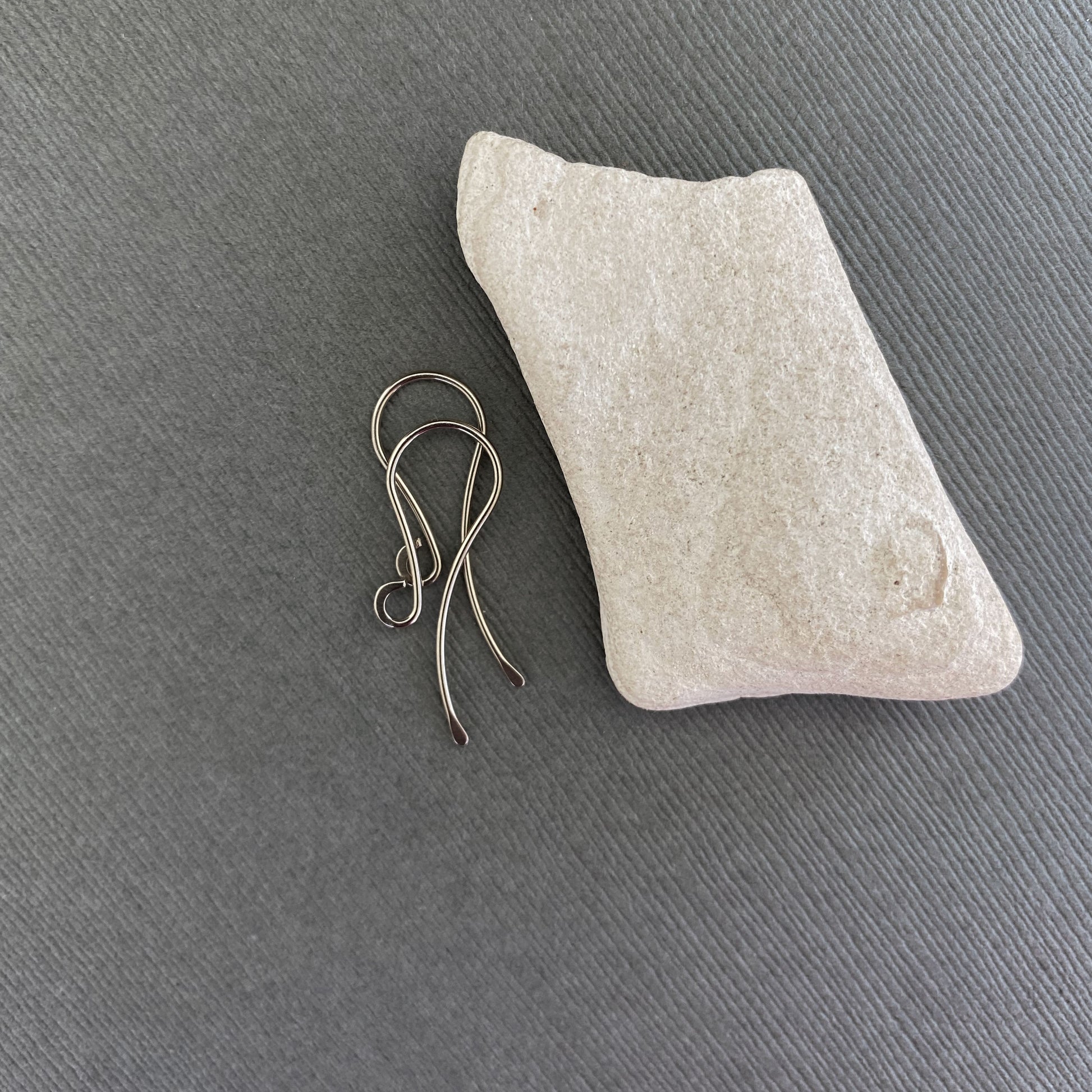 A pair of handmade 14K Palladium White Gold earring wires with a hammered front loop, displayed against a neutral background.