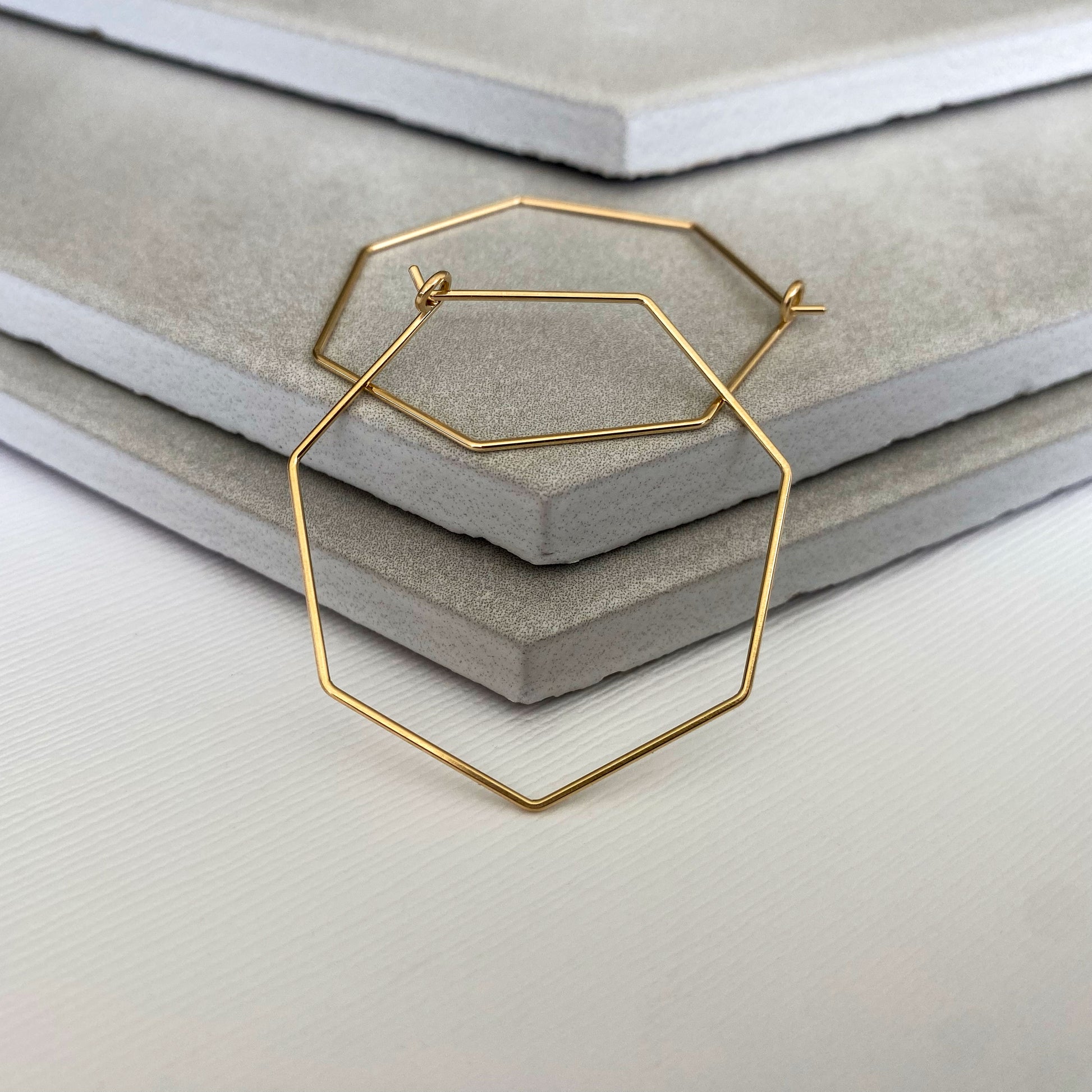 Handcrafted 14k gold-filled heptagon hoop earrings with a polished finish.