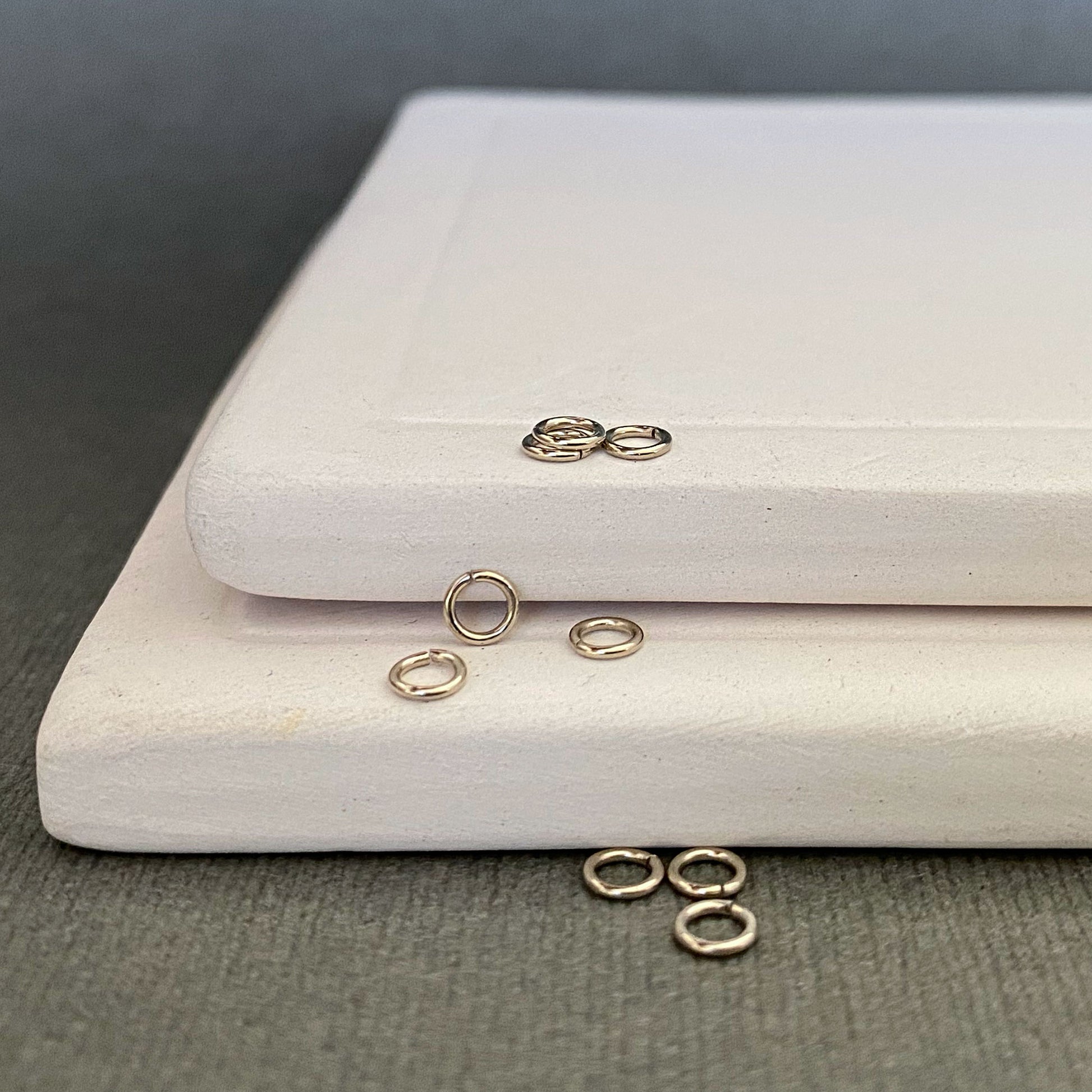 14k white gold palladium jump rings, 2.5mm, highlighting their uniform size and polished finish.