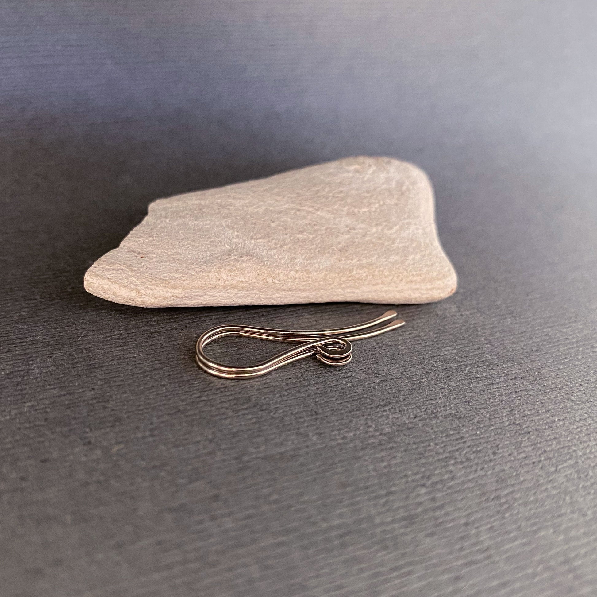 A zoomed-in view of the hammered and flared front loop on handmade 14K Palladium White Gold ear wires.