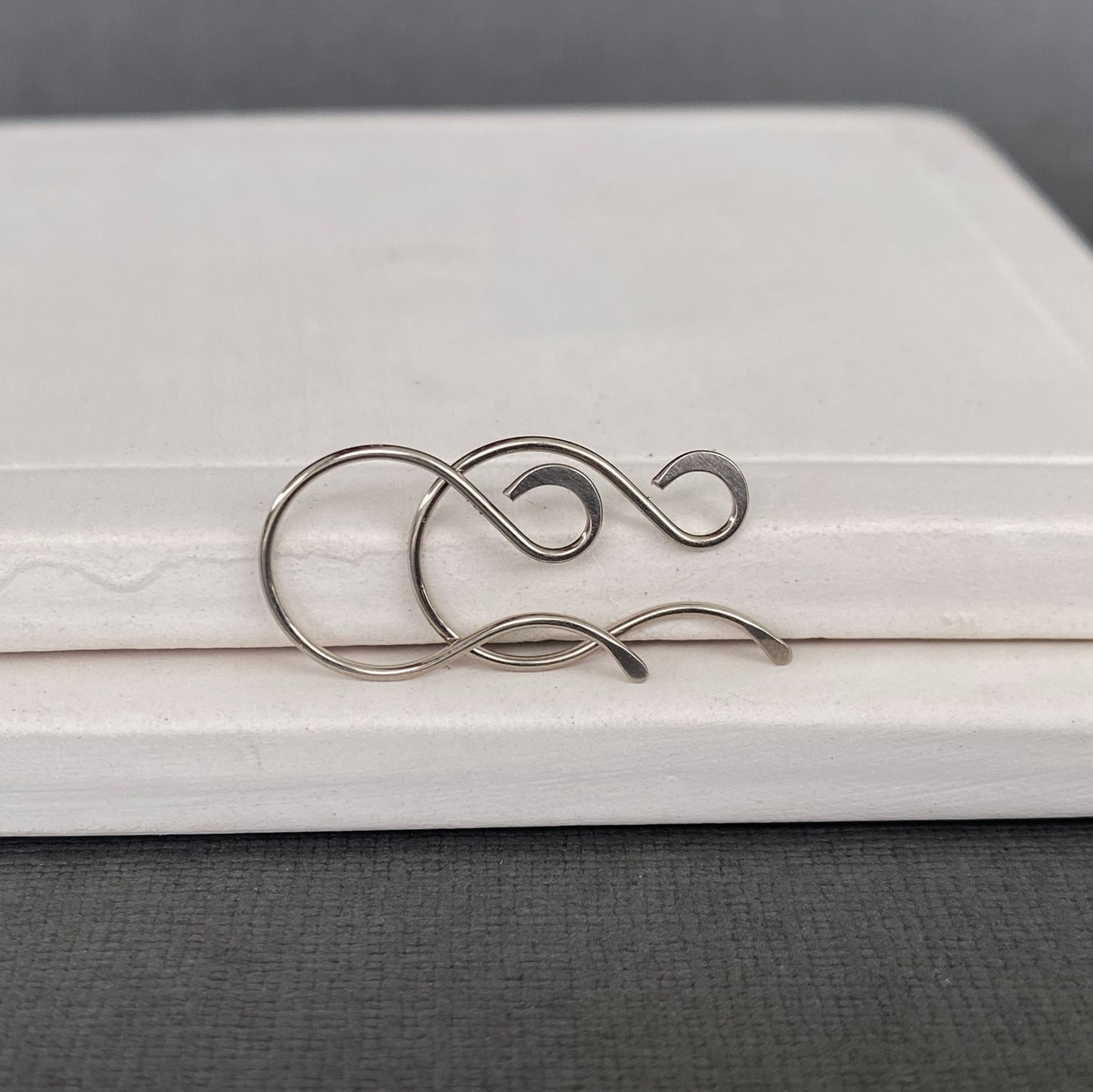 Close-up of smooth, sanded ends on handmade 14k Palladium White Gold earring wires