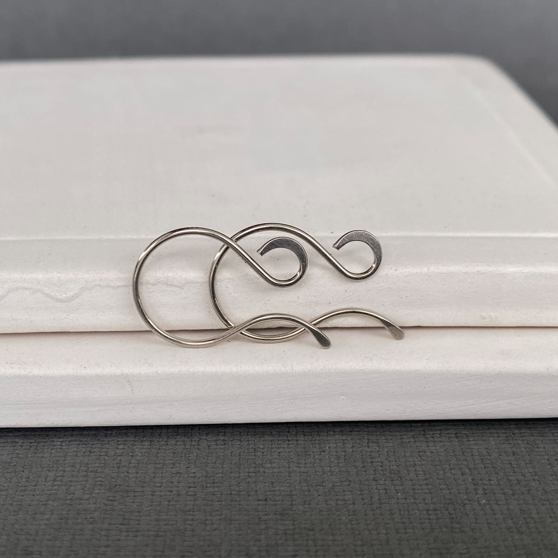 Close-up of smooth, sanded ends on handmade 14k Palladium White Gold earring wires