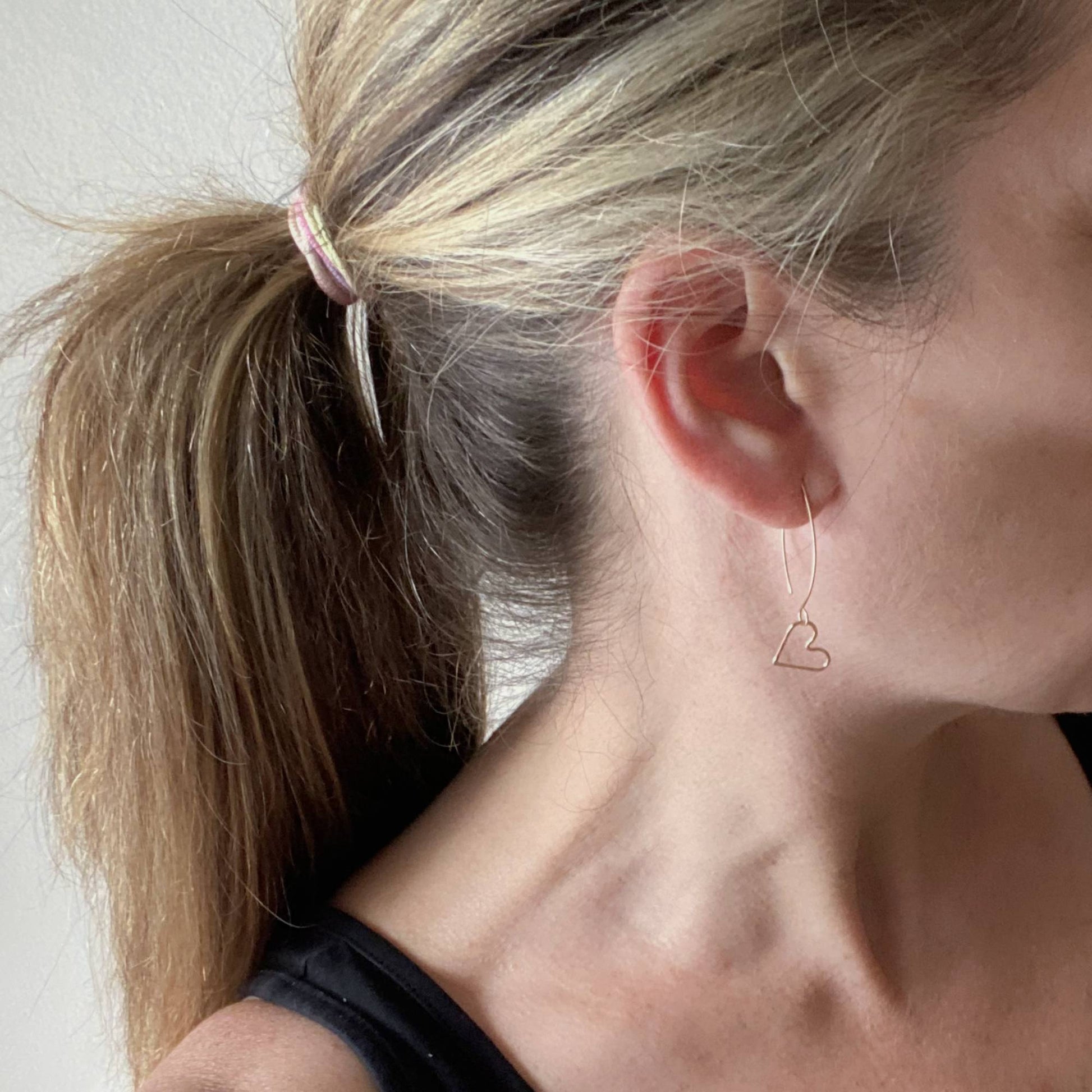 14k gold earwires being worn on a model to show scale.