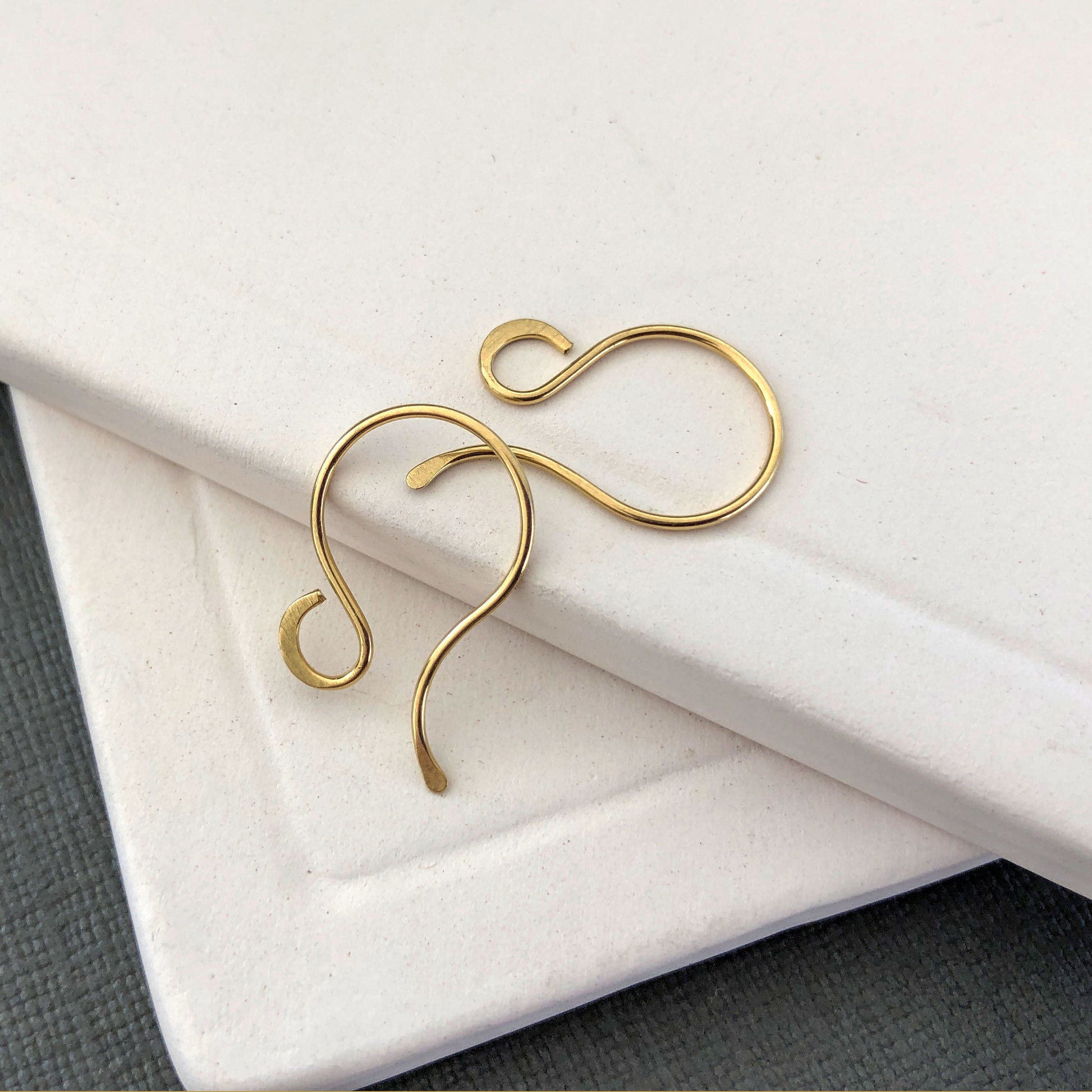 Handmade 18k solid gold earring hooks on white background