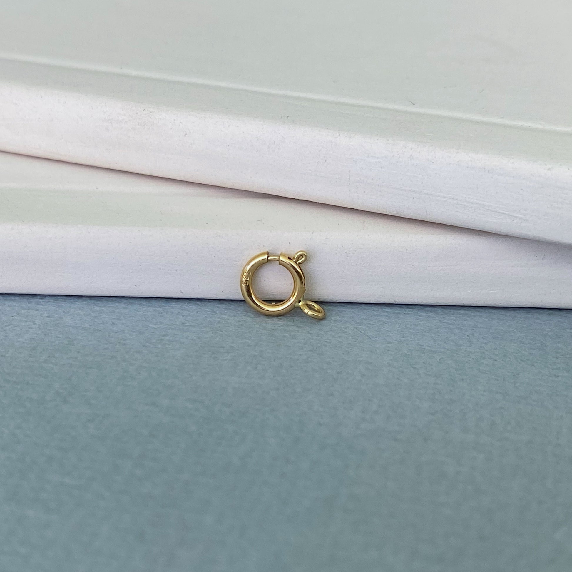 Detailed view of an Italian-made 14k gold spring ring clasp with a 585 hallmark