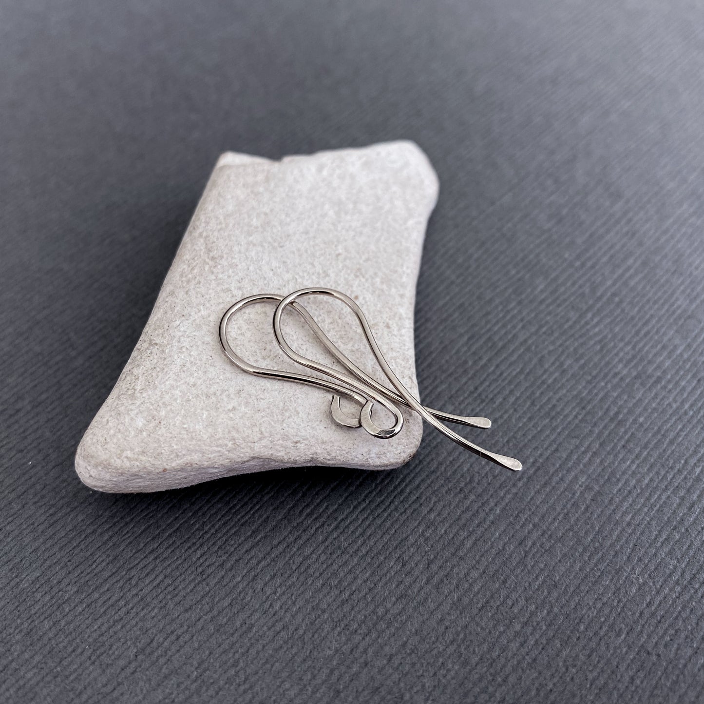 Side angle of solid 14K Palladium White Gold earring hooks, showing their smooth, handcrafted finish.