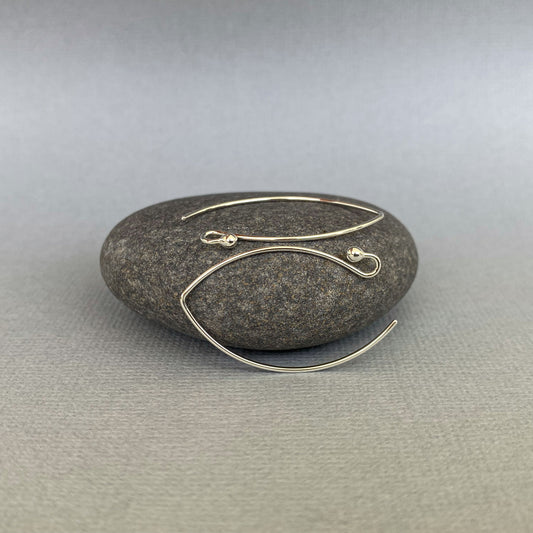Handmade Argentium silver ball-end earring hooks displayed against a neutral background, showing their smooth and polished finish.