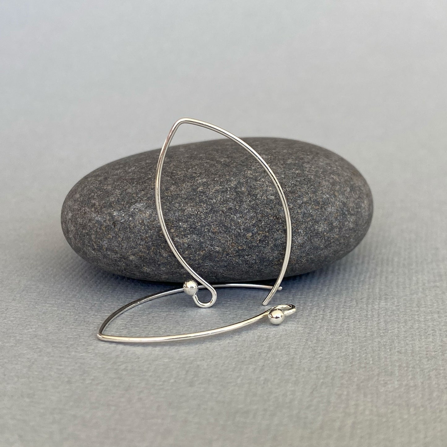 Back view of handmade Argentium silver ear wires, emphasizing their curved shape and sturdy design.