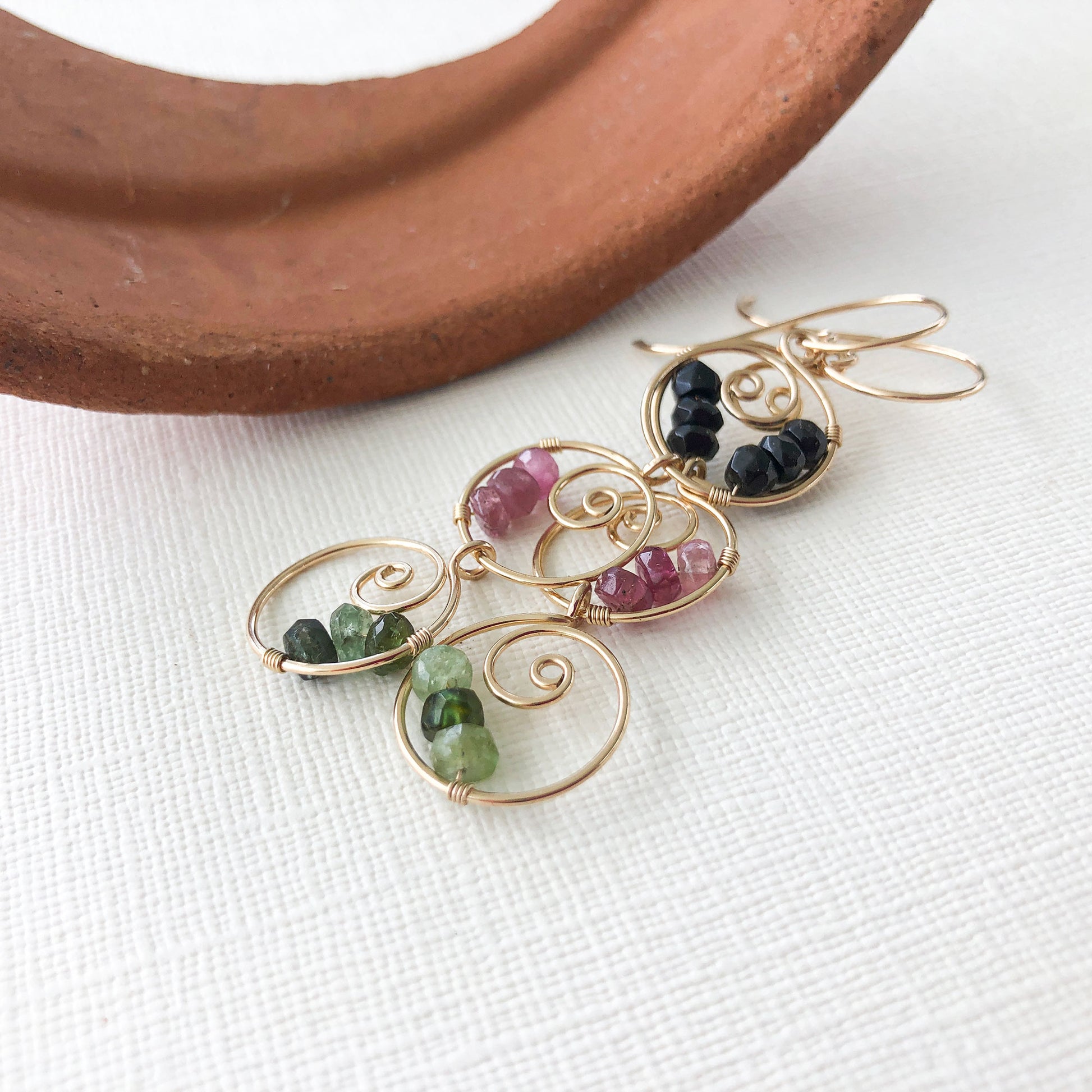 Side angle of handmade gold-filled earrings – A detailed look at the hammered and sanded ear wires, showcasing the craftsmanship and unique flared finish.