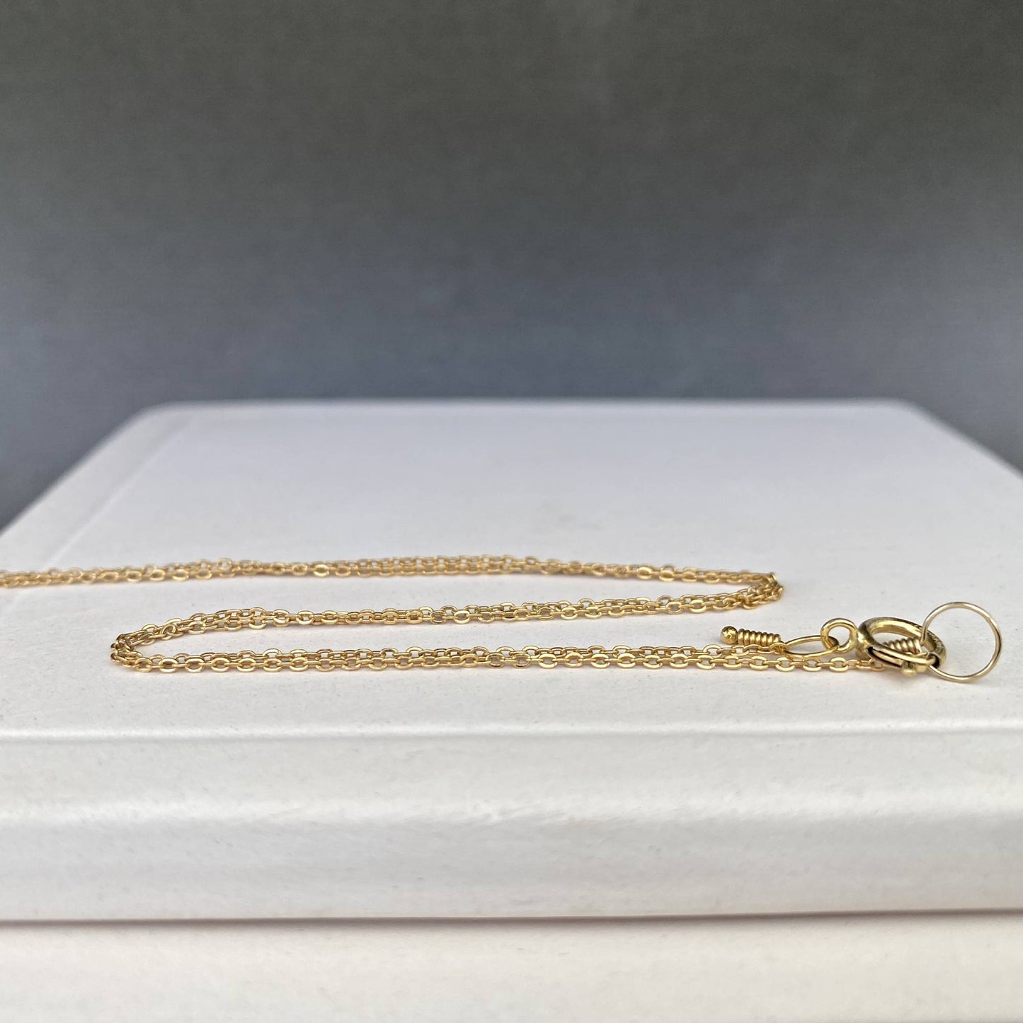 Two 14k gold filled custom-length chains laid side-by-side to show their versatility for a stacking look.