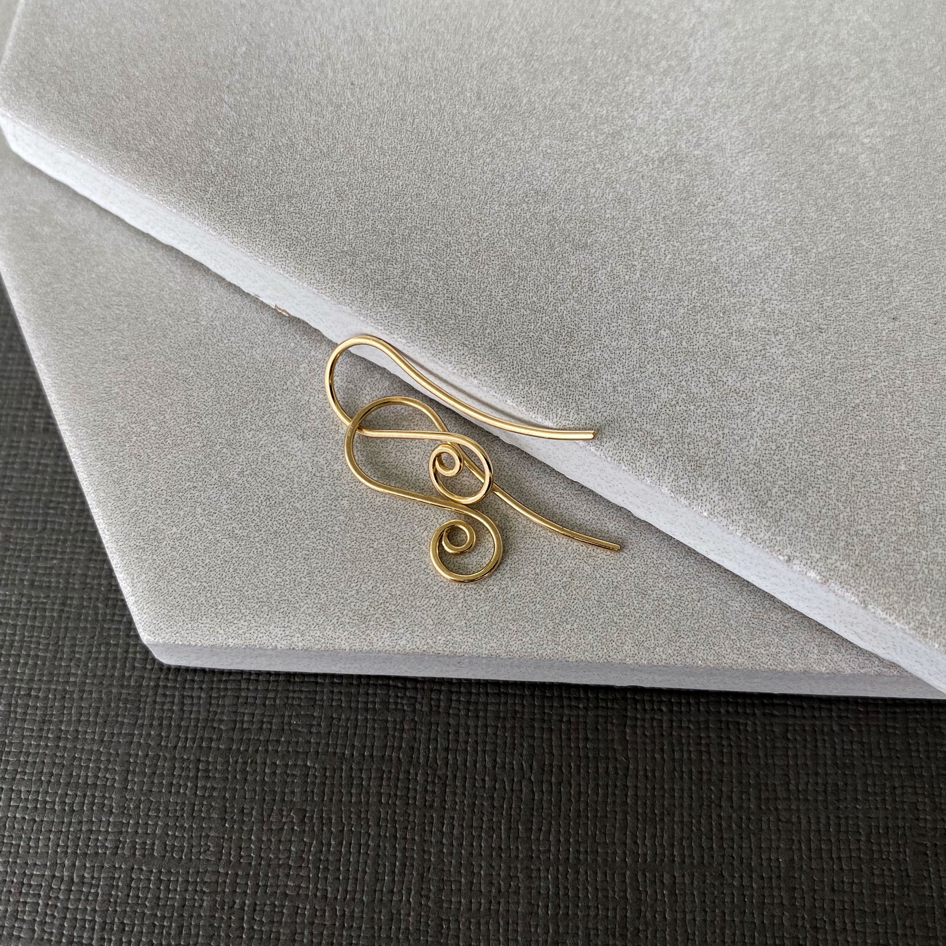 Handmade 10K gold spiral earring hooks with a smooth, polished finish for a refined look.