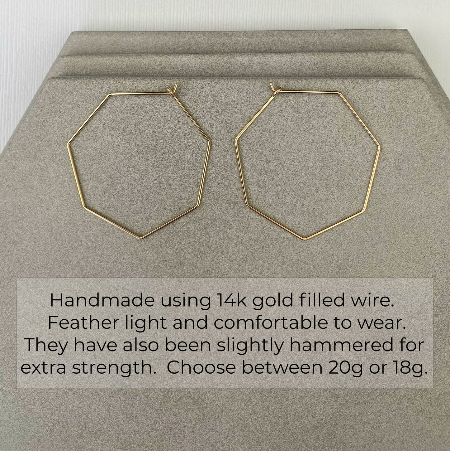 Handcrafted 14k gold-filled heptagon hoop earrings with a geometric design at an angled view.