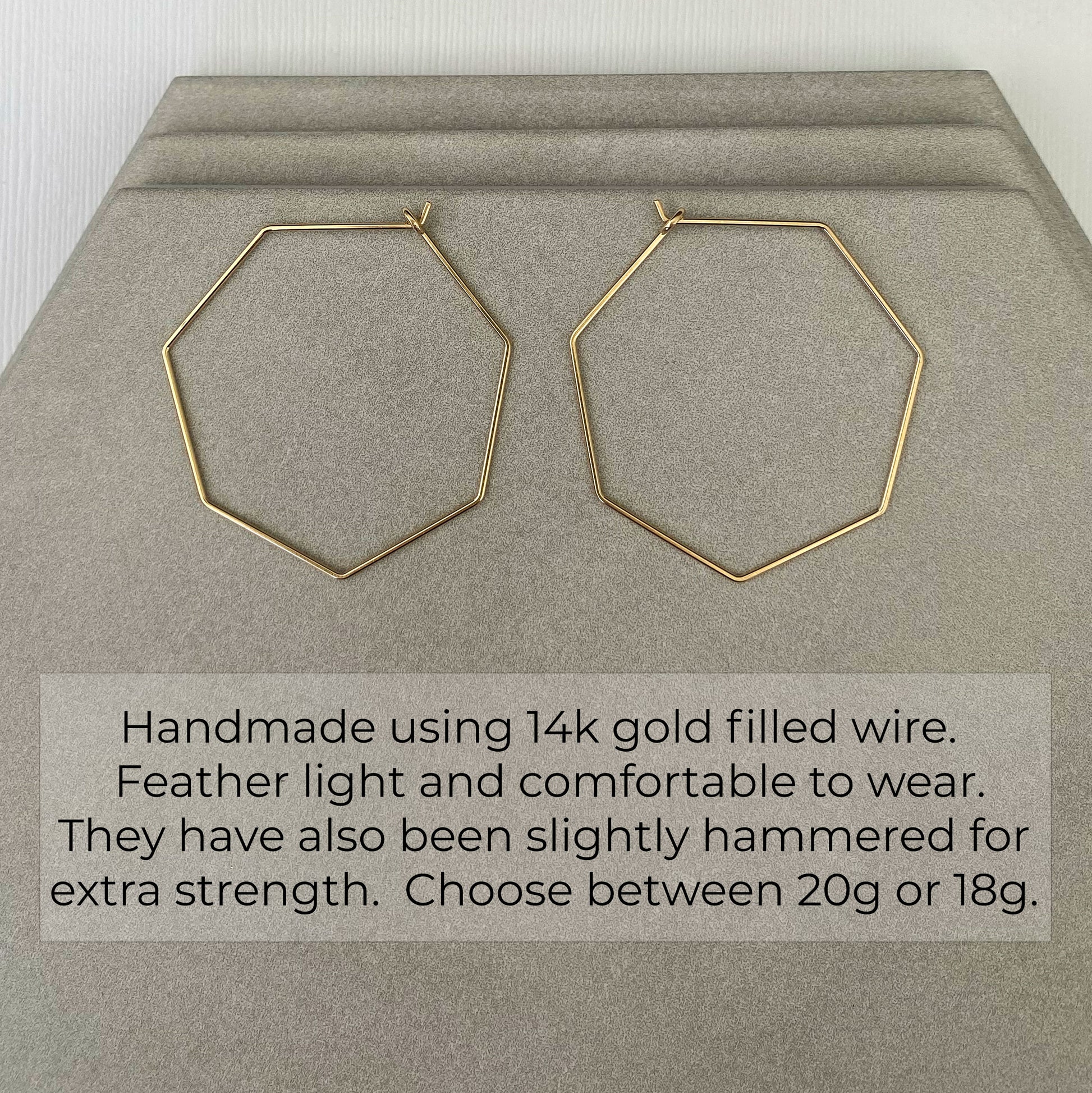 Handcrafted 14k gold-filled heptagon hoop earrings with a geometric design at an angled view.