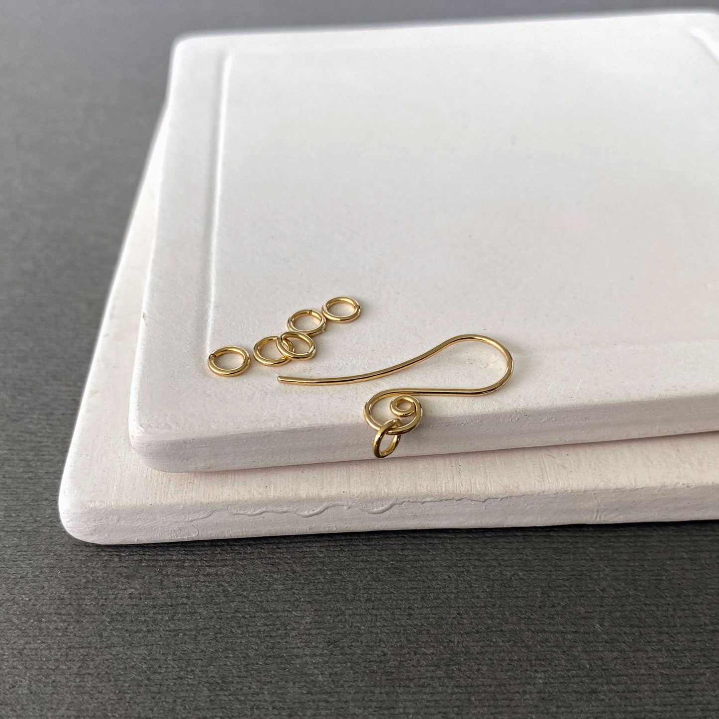 Close-up view of solid gold jump rings with smooth cuts and minimal gaps for secure connections.