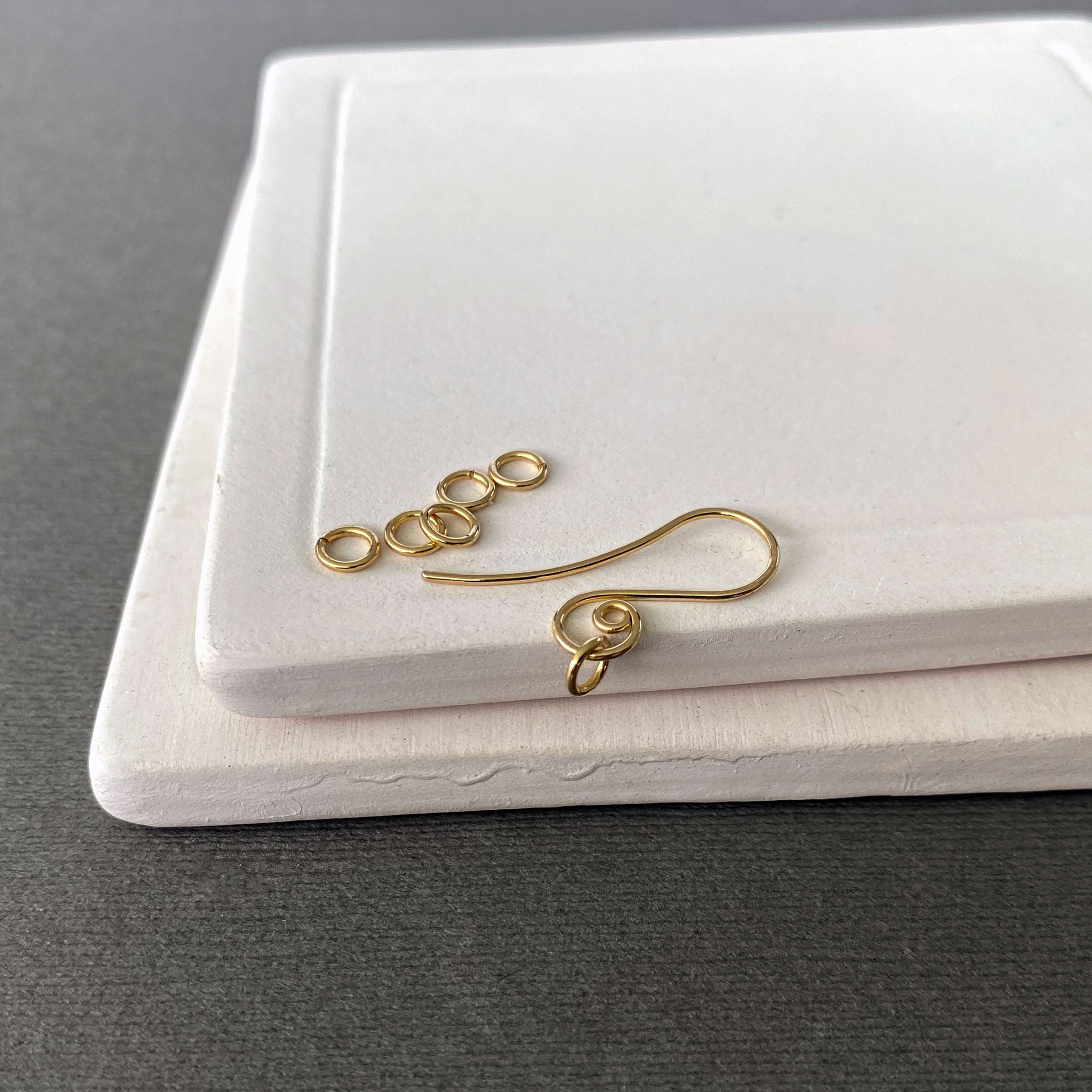 Close-up view of solid gold jump rings with smooth cuts and minimal gaps for secure connections.