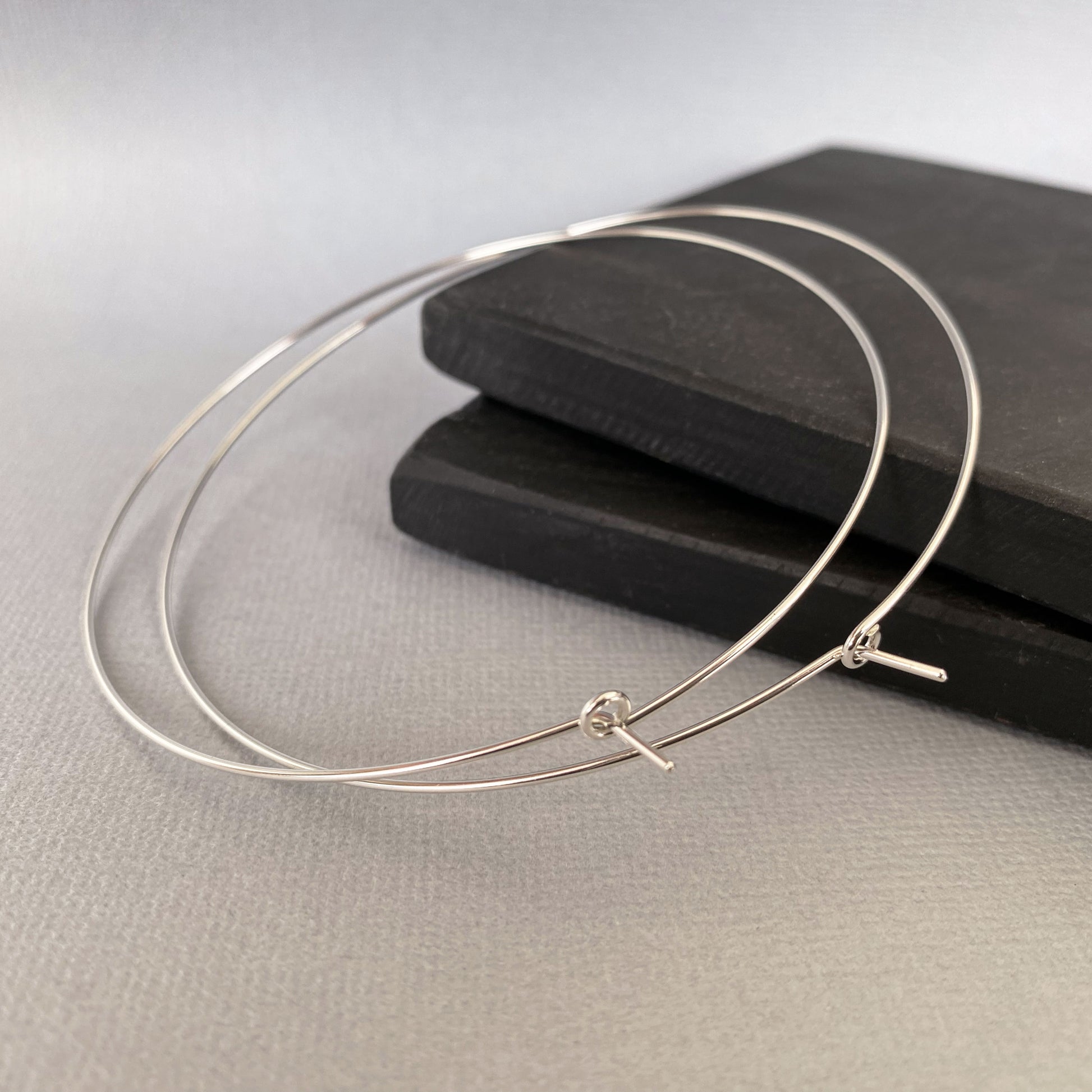 Close-up of large, lightweight sterling silver hoop earrings, designed for all-day comfort.