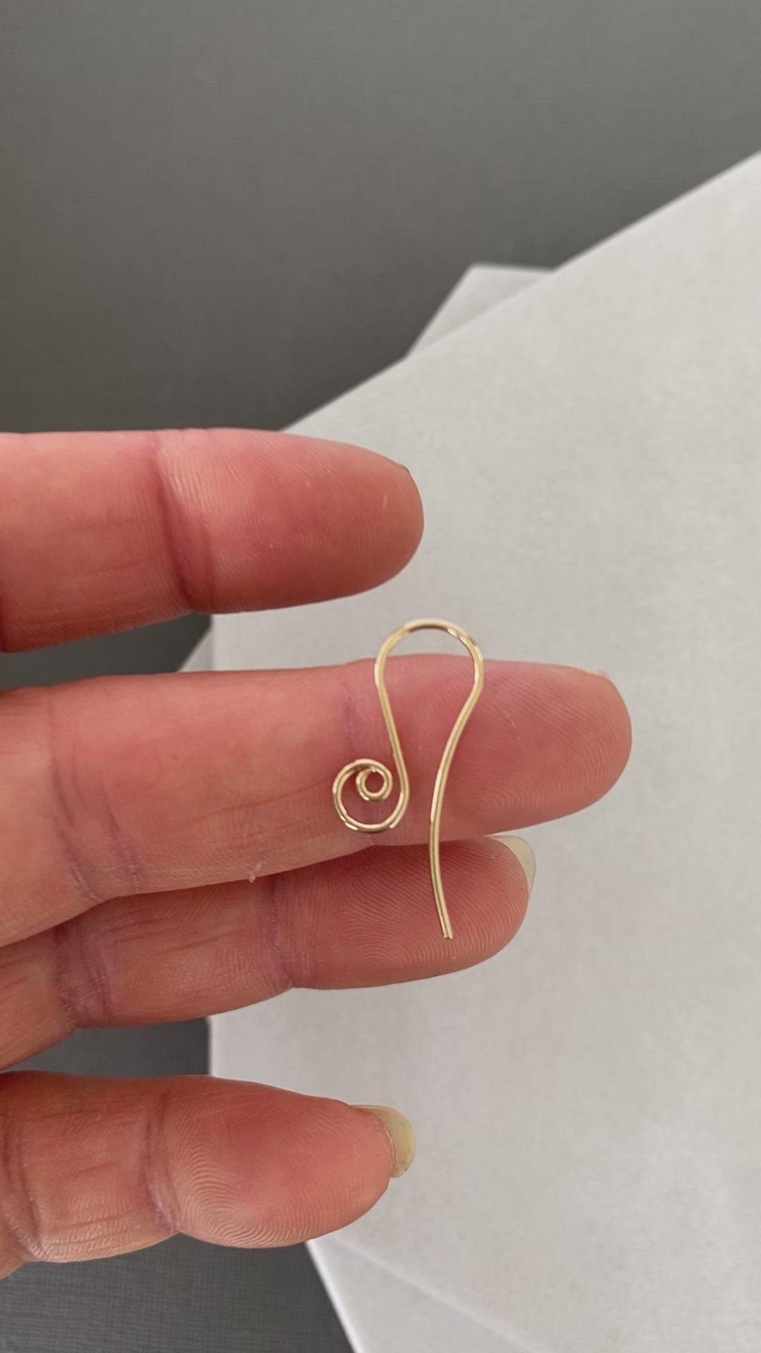A pair of handcrafted 10K solid gold spiral earring hooks, perfect for jewelry making.