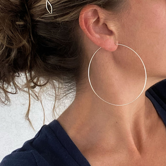 A model wearing sterling silver hoop earrings, highlighting their elegant and versatile size.