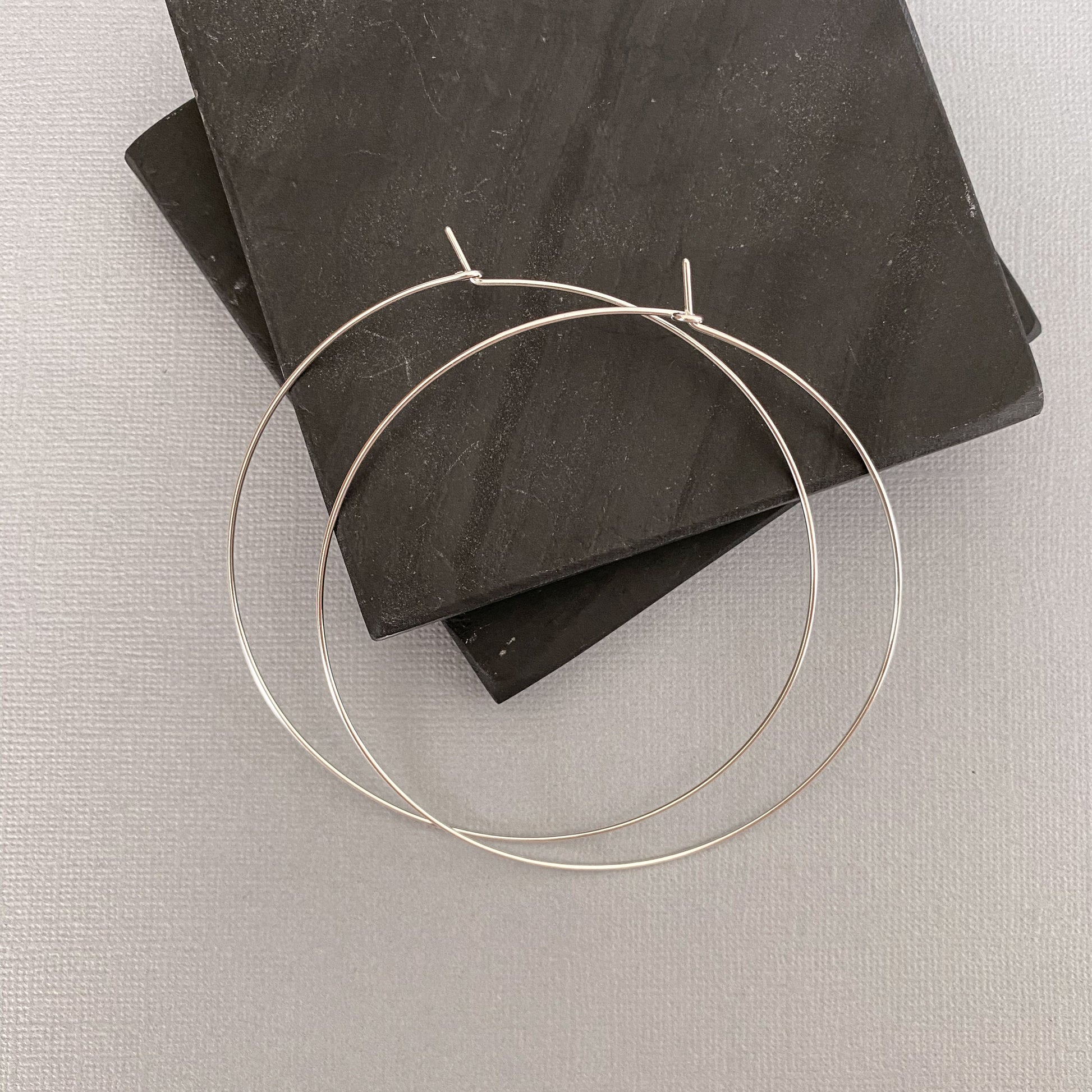 Side view of sterling silver hoop earrings, showcasing their thin yet sturdy construction.