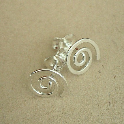 Close-up of handmade sterling silver spiral stud earrings with butterfly backs