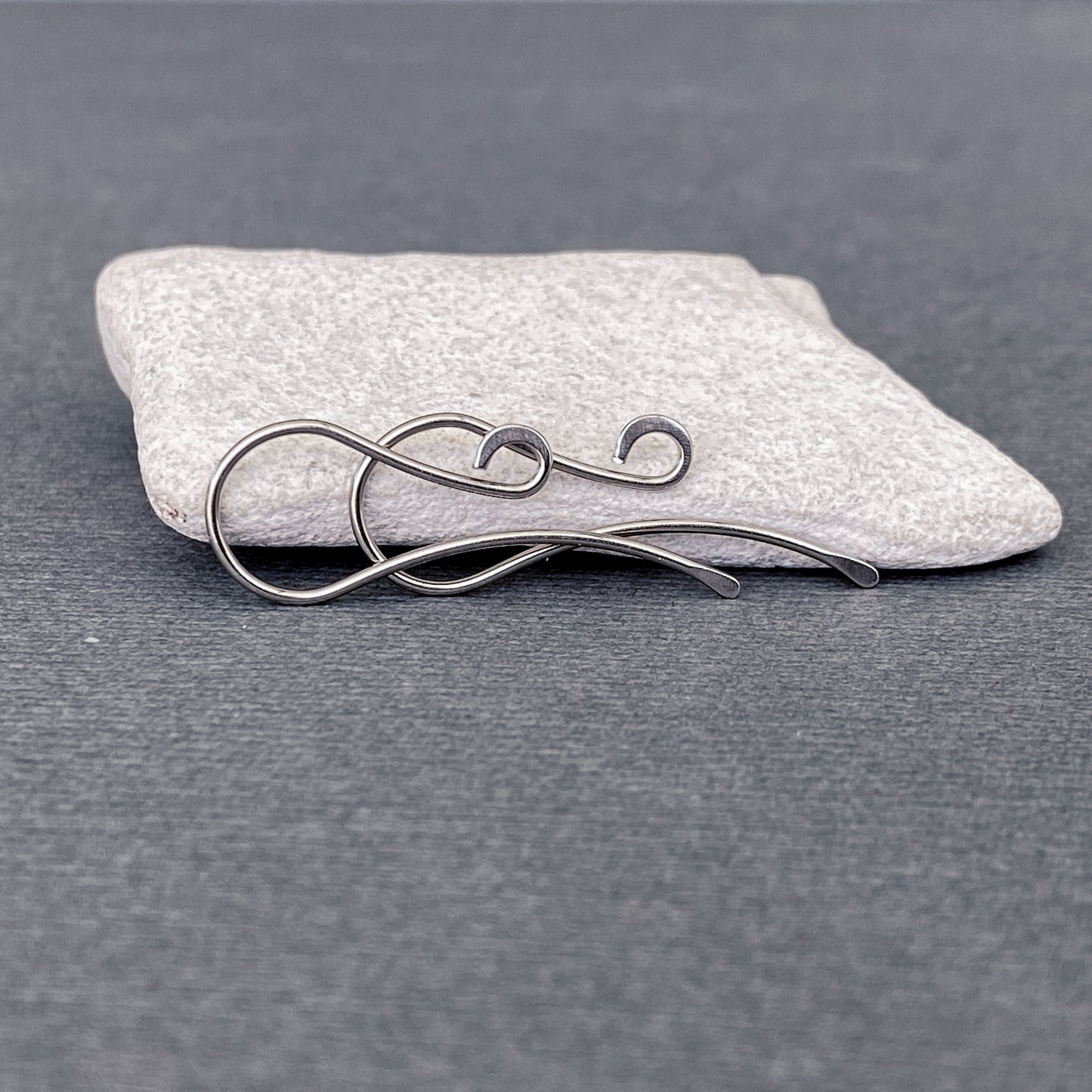 Detailed shot of a pair of 20-gauge Palladium White Gold ear hooks, showing their strength and craftsmanship.