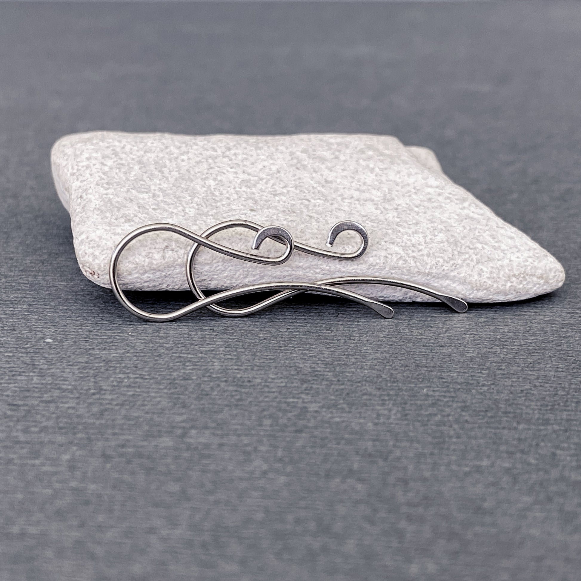 Detailed shot of a pair of 20-gauge Palladium White Gold ear hooks, showing their strength and craftsmanship.