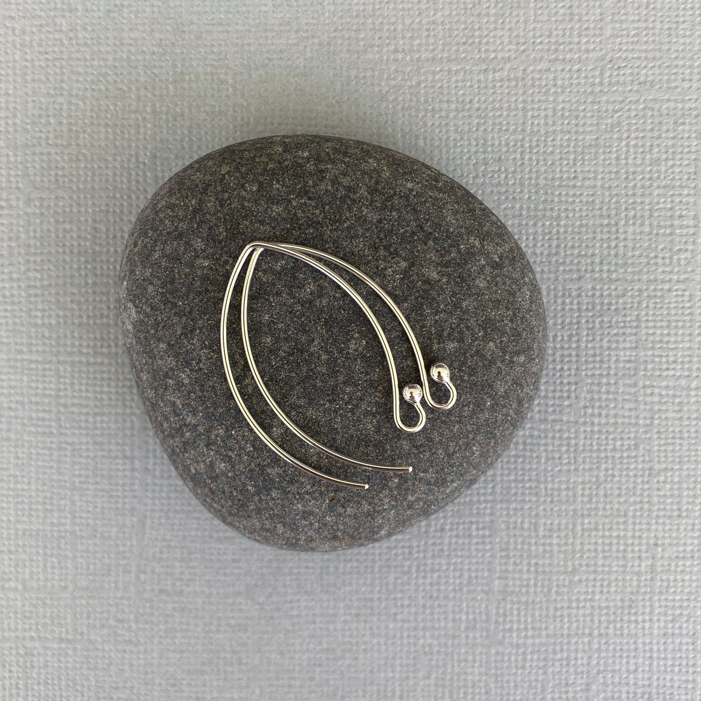 Close-up of Argentium silver ball-end earring hooks, highlighting the bright finish and precision craftsmanship.