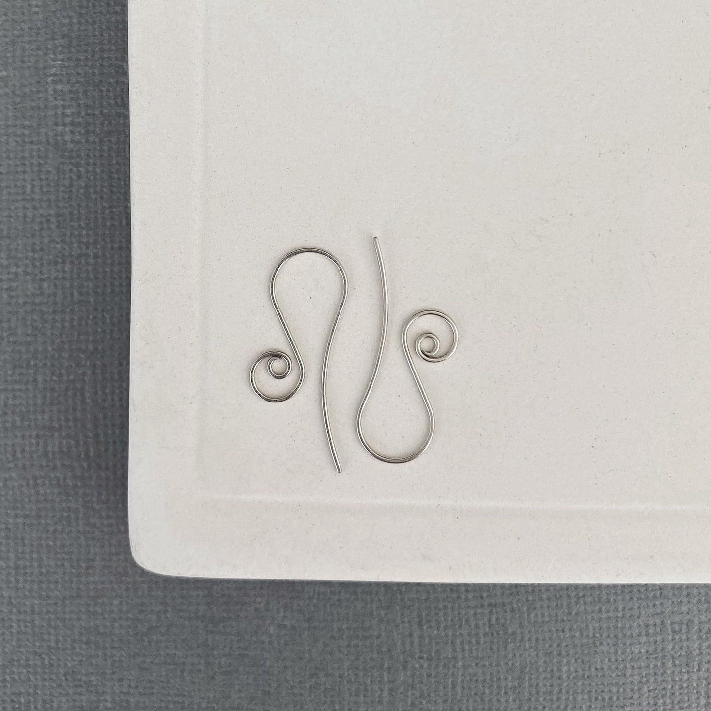 Handmade white gold earring hooks with hammered and flared design