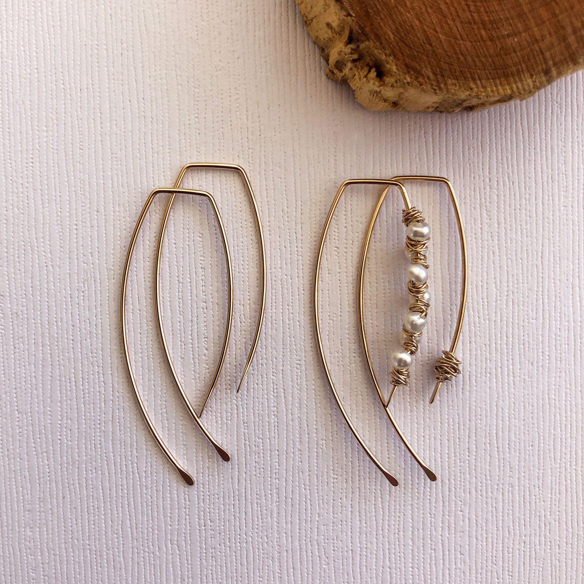 gold filled earring threaders.  They measure just over 1 inch.  the back is longer than the front and both sides have been hammered to give them a unique look.  There is another pair next to them that show how they can be embelished with pearls or wire