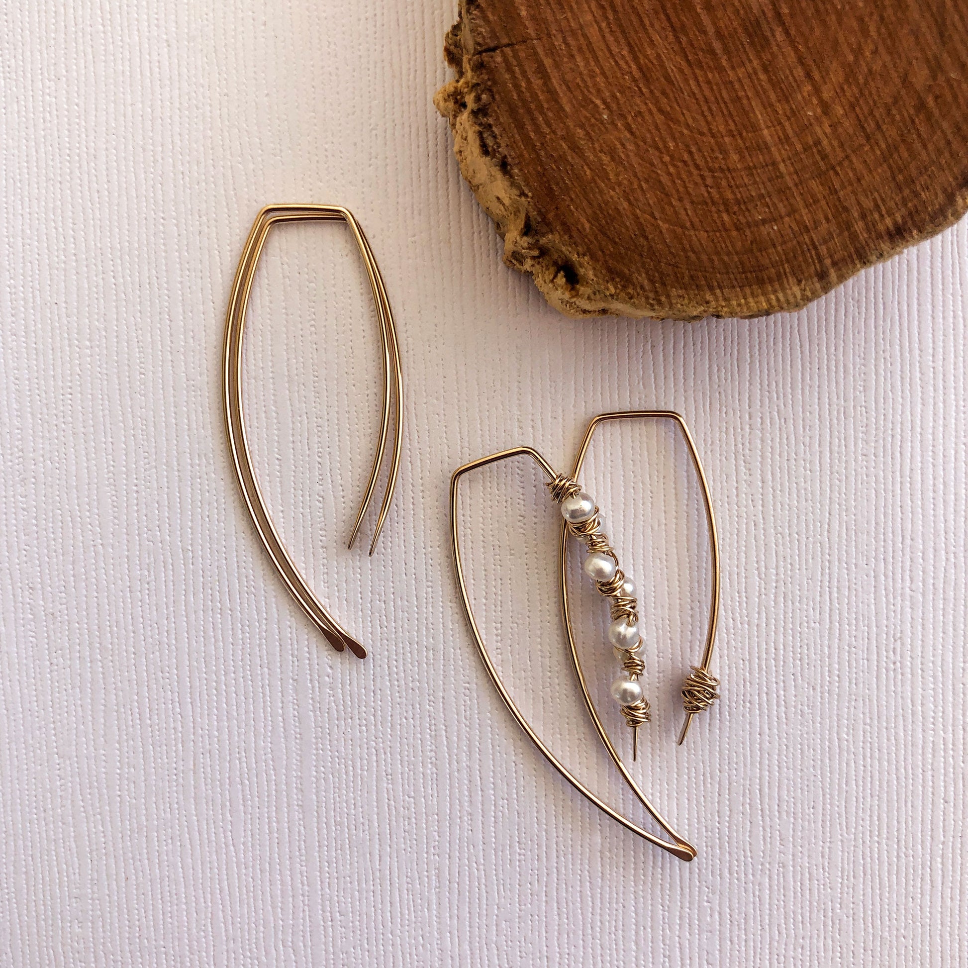 gold filled earring threaders. They measure just over 1 inch. the back is longer than the front and both sides have been hammered to give them a unique look. There is another pair next to them that show how they can be embelished with pearls or wire