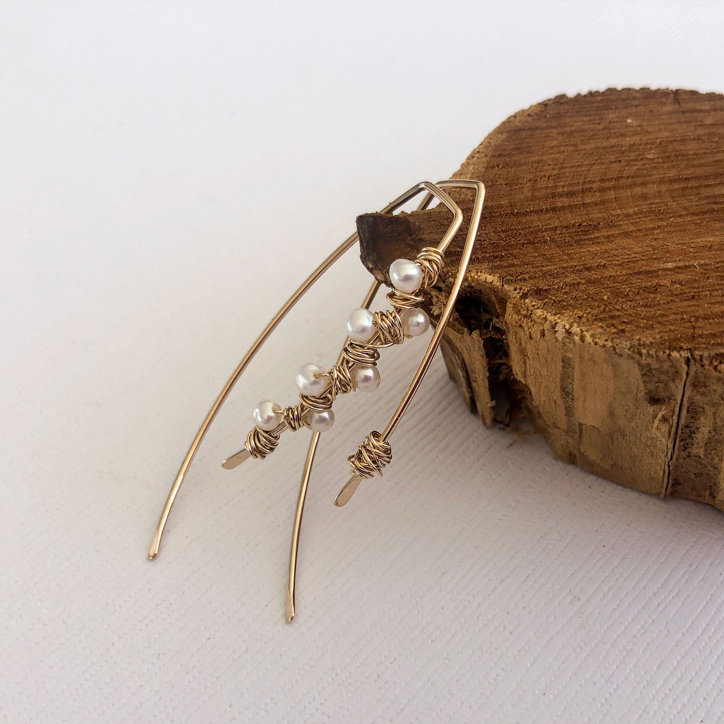gold filled mismatched ear wires. one has pearls wrapped around it and the other has a messy wire wrap. Hammered ends. These are sold by the pair.