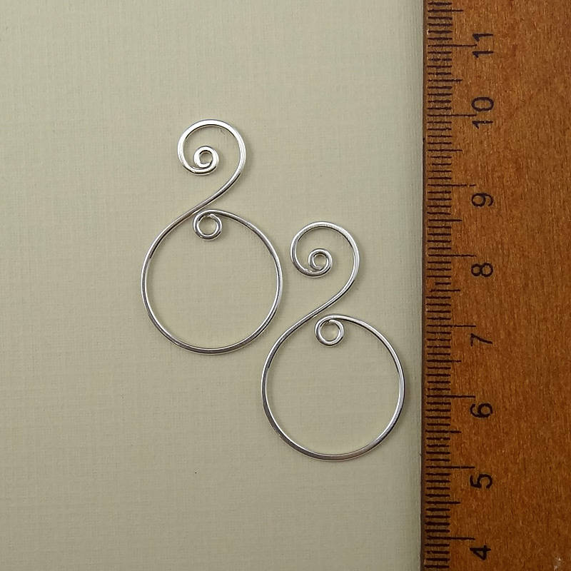 A single sterling silver spiral charm photographed from an overhead perspective, perfect for jewelry-making projects.