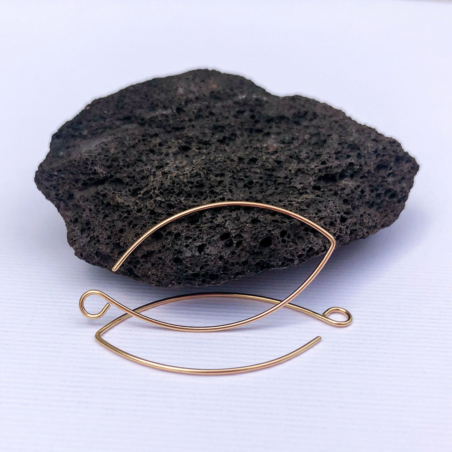 20 gauge solid gold earring findings in marquise shape, laid flat.