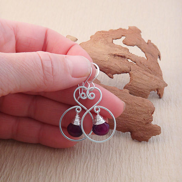 Close-up of sterling silver spiral earrings, showcasing the elegant handcrafted swirls and hammered finish.