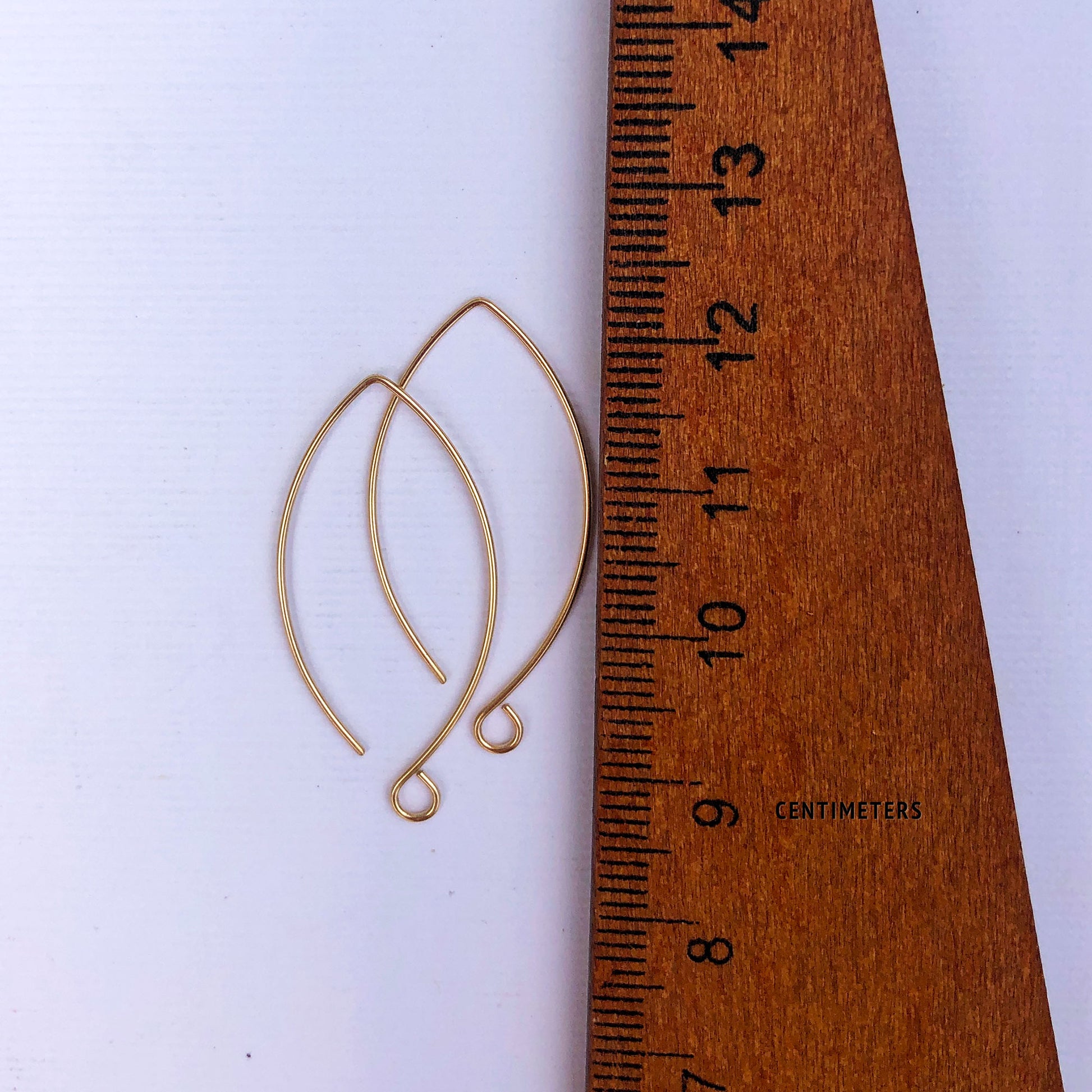 Model wearing handmade 14k gold ear wires in 22 gauge for size reference.