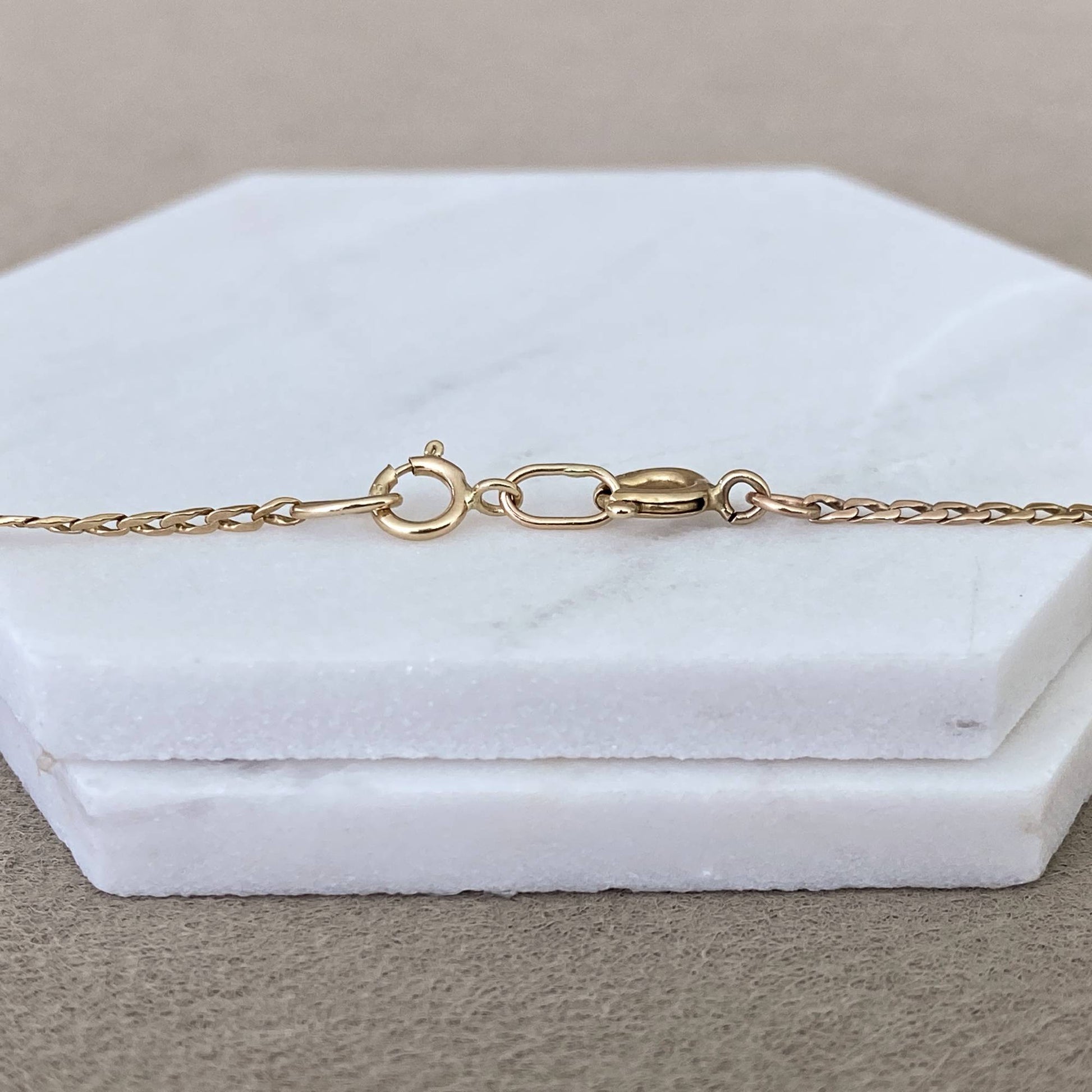 14k solid gold chain extender attached to gold necklace showing how it works