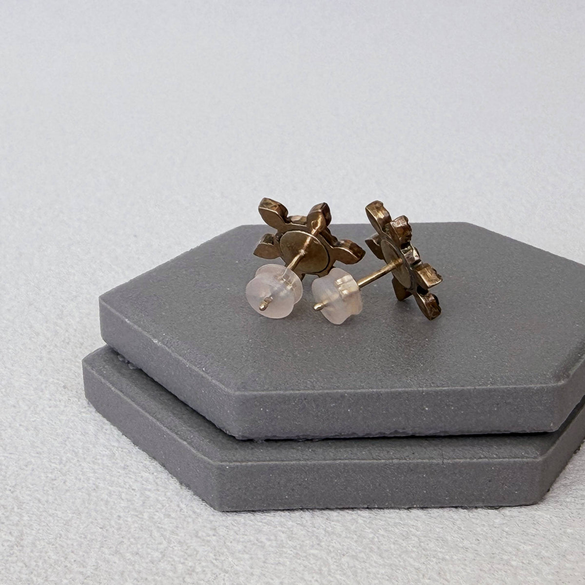Close-up detail of 14K yellow gold components inside silicone earring backs