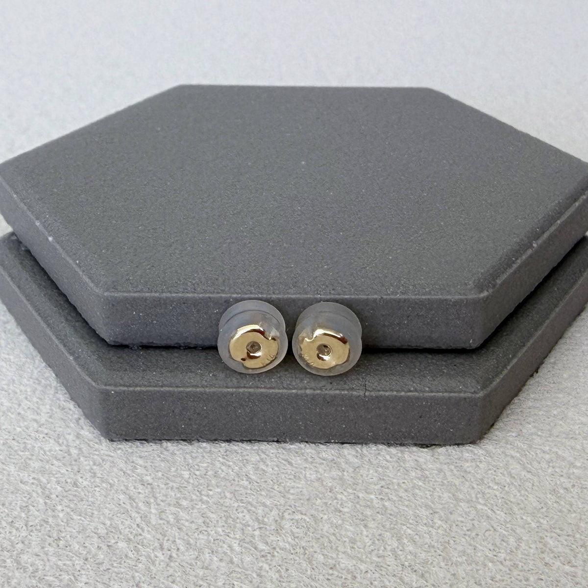 Pair of 14K solid gold silicone earring backs viewed from another angle