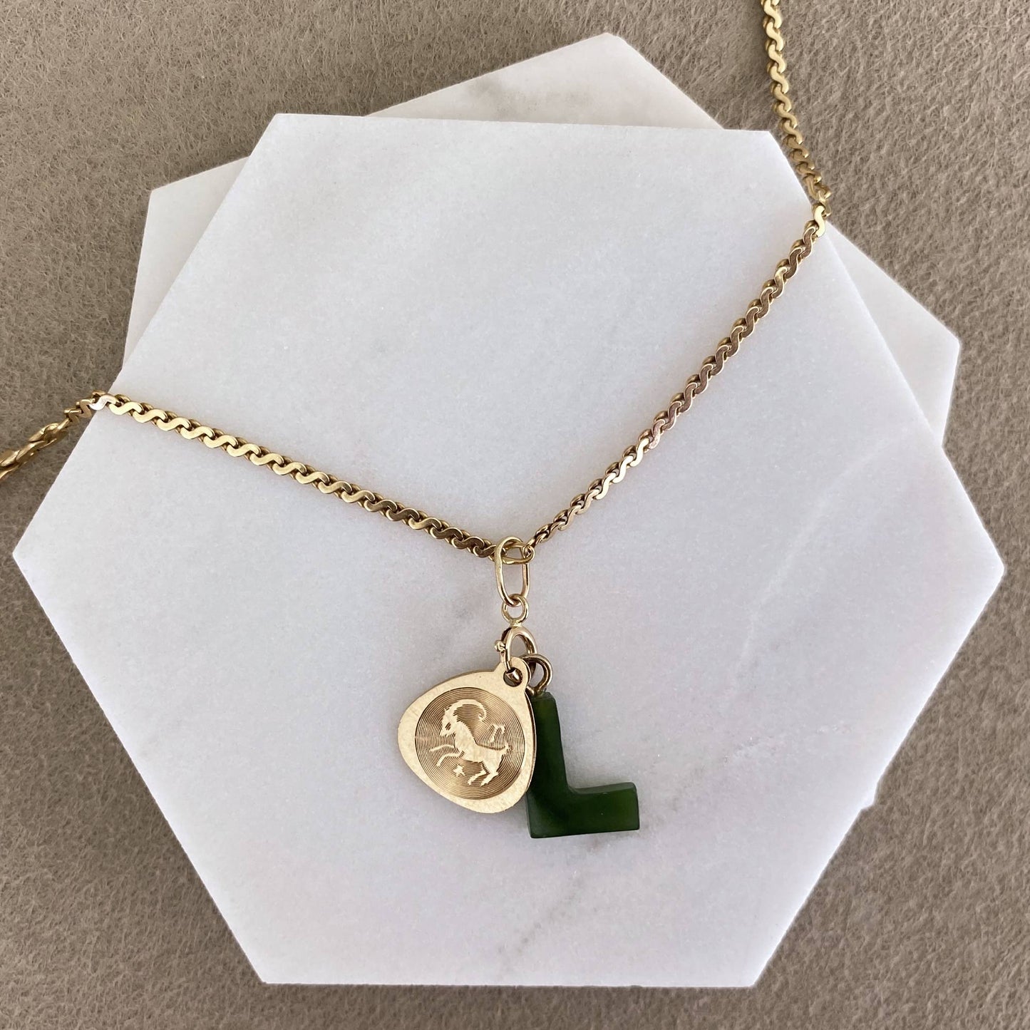 14k solid gold charm holder necklace flat lay with coin pendant and jade initial charm