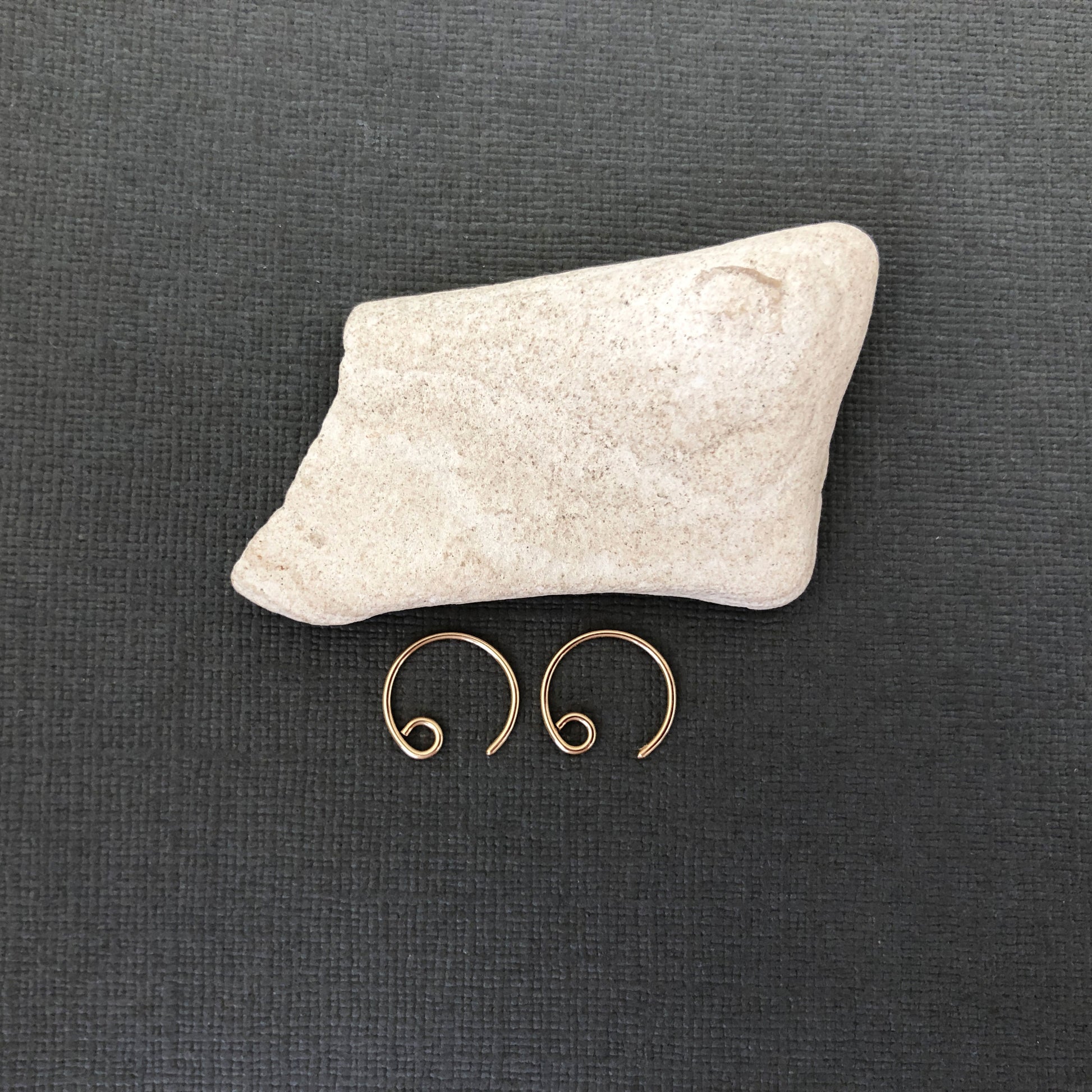 Detail view of polished 14k gold filled tiny hoop earrings
