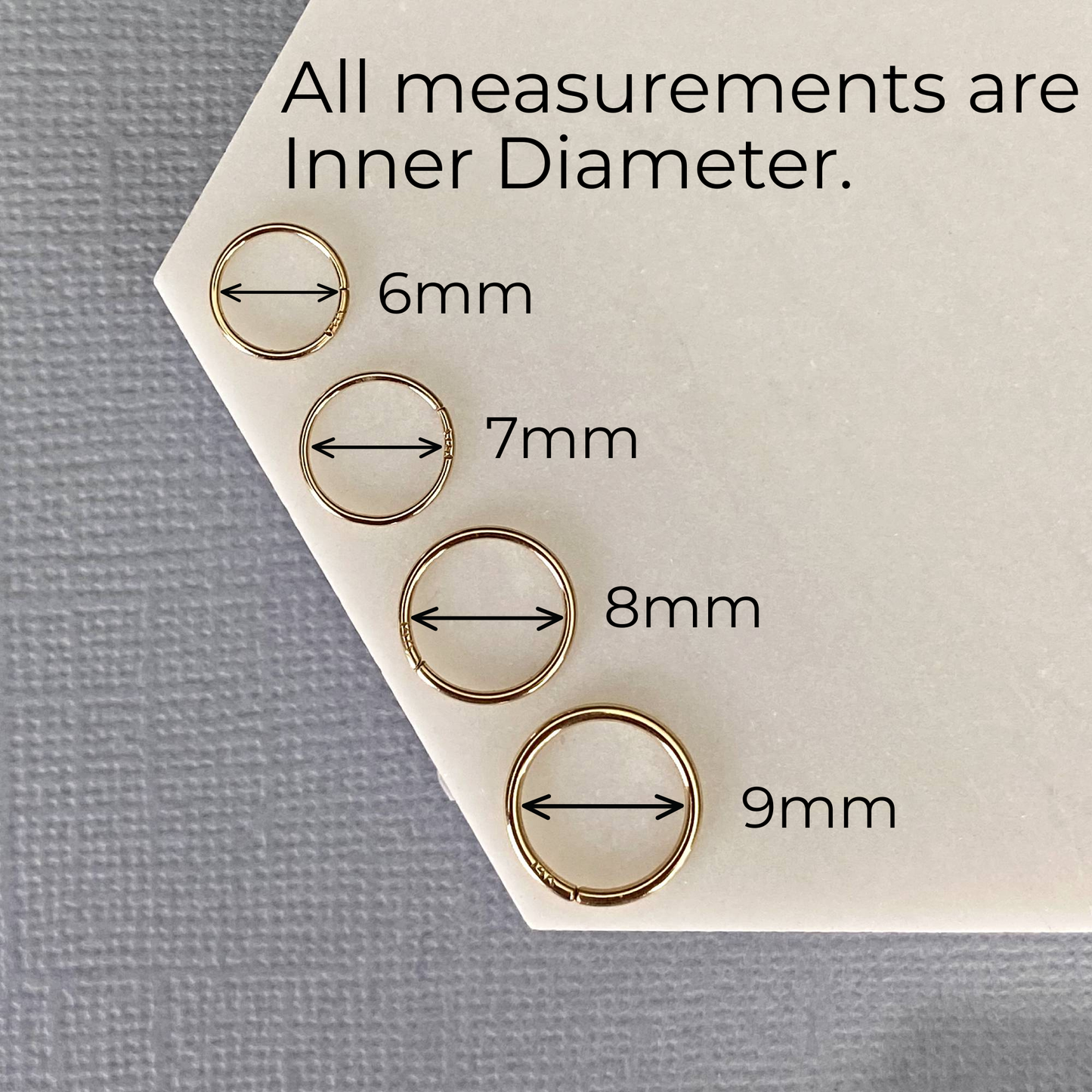 Measurement chart showing inner diameters of gold rings on a gray background
