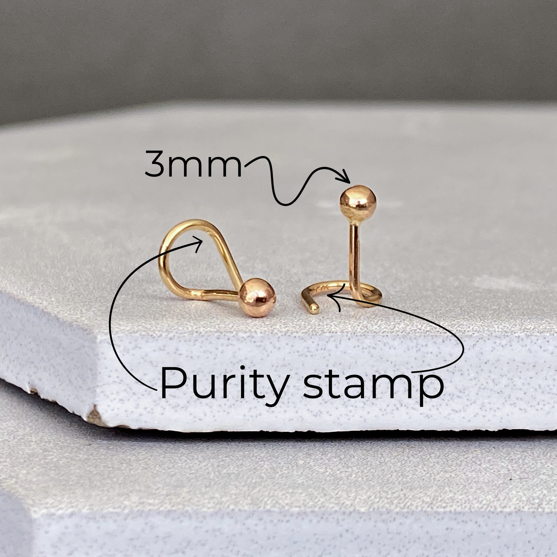 Gold purity stamp with measurements on a white stone Detailed view of the 14k solid gold 3mm ball studs surface