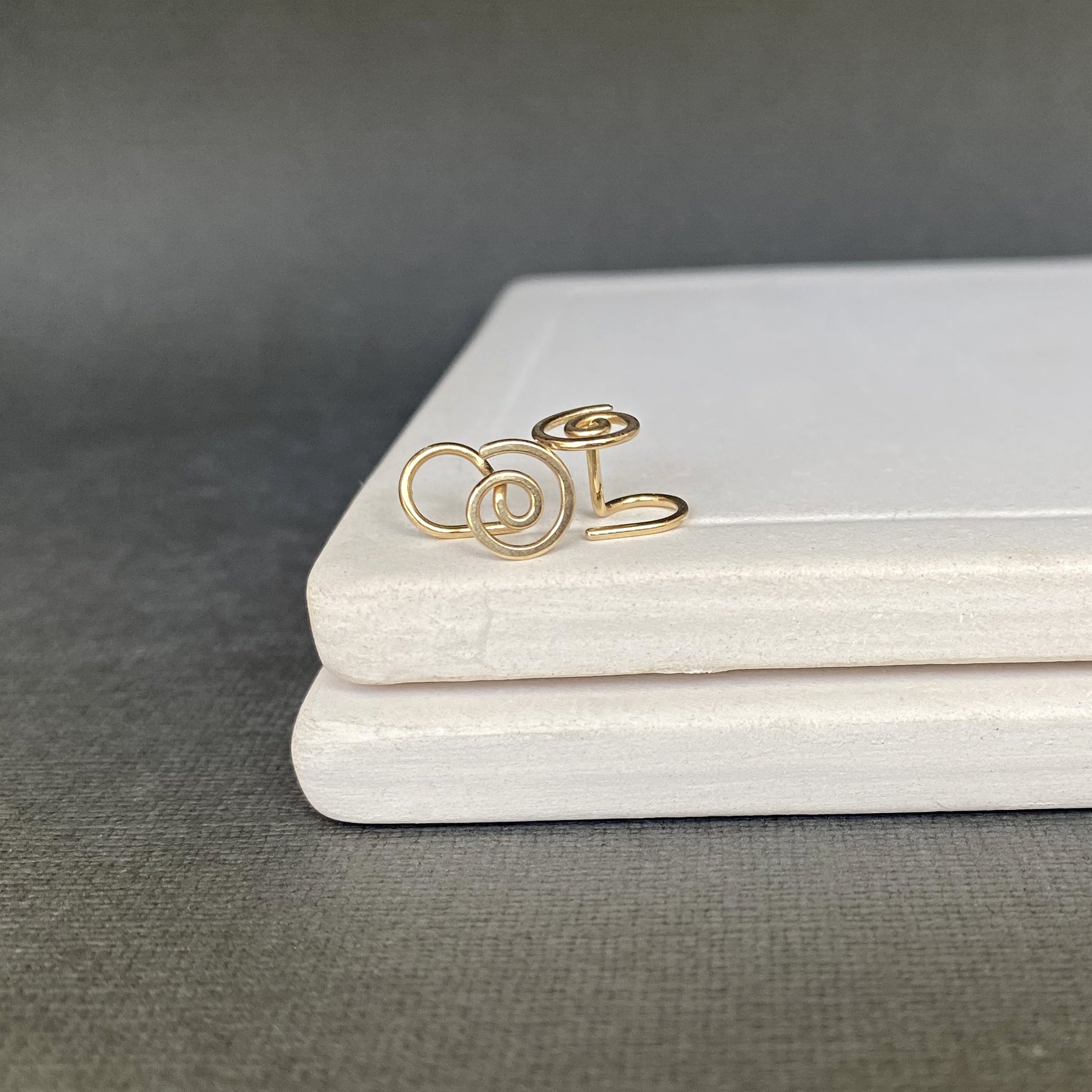 Gold ring with a floral design on a gray surface