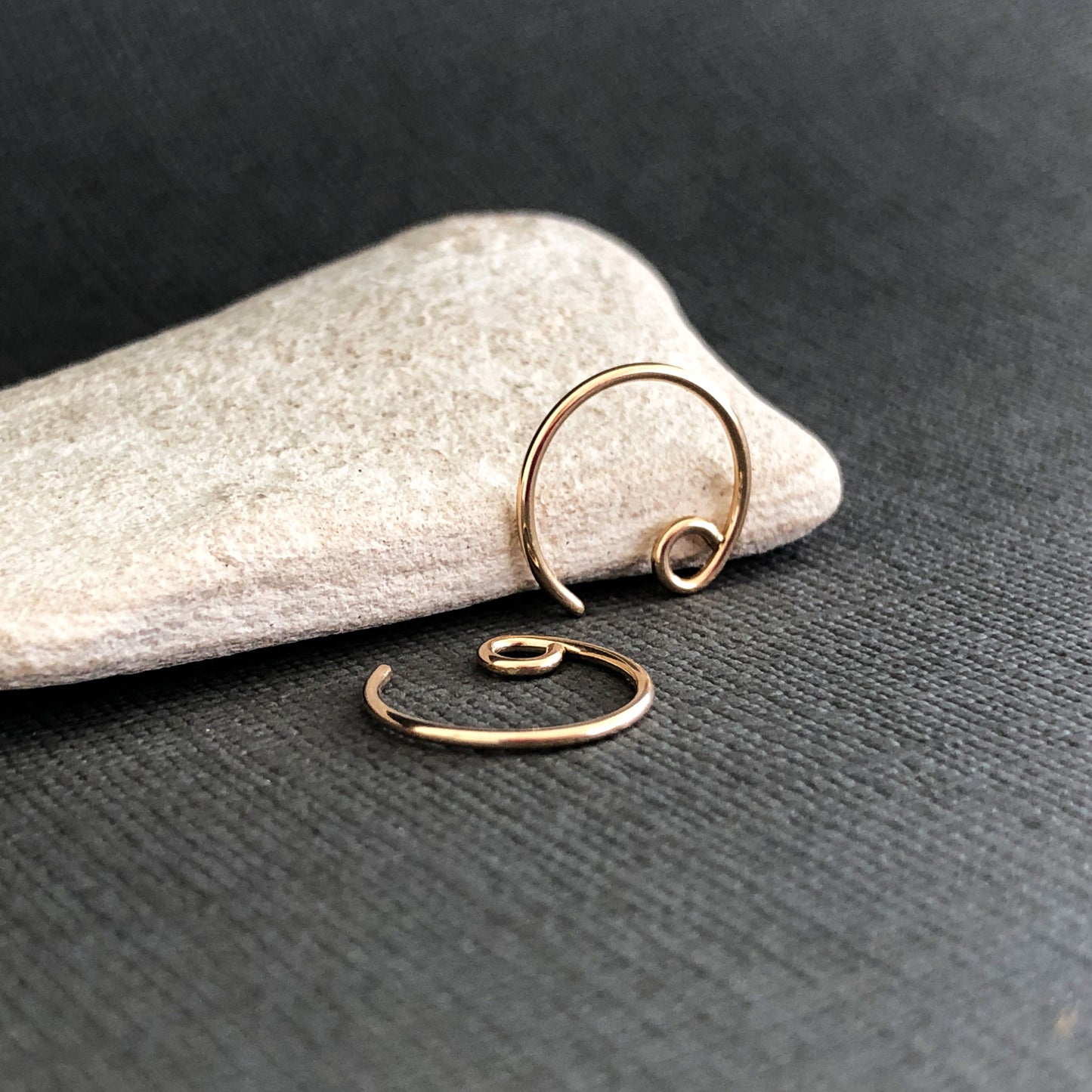 Close-up of tiny 14k gold filled hoop earrings on white background